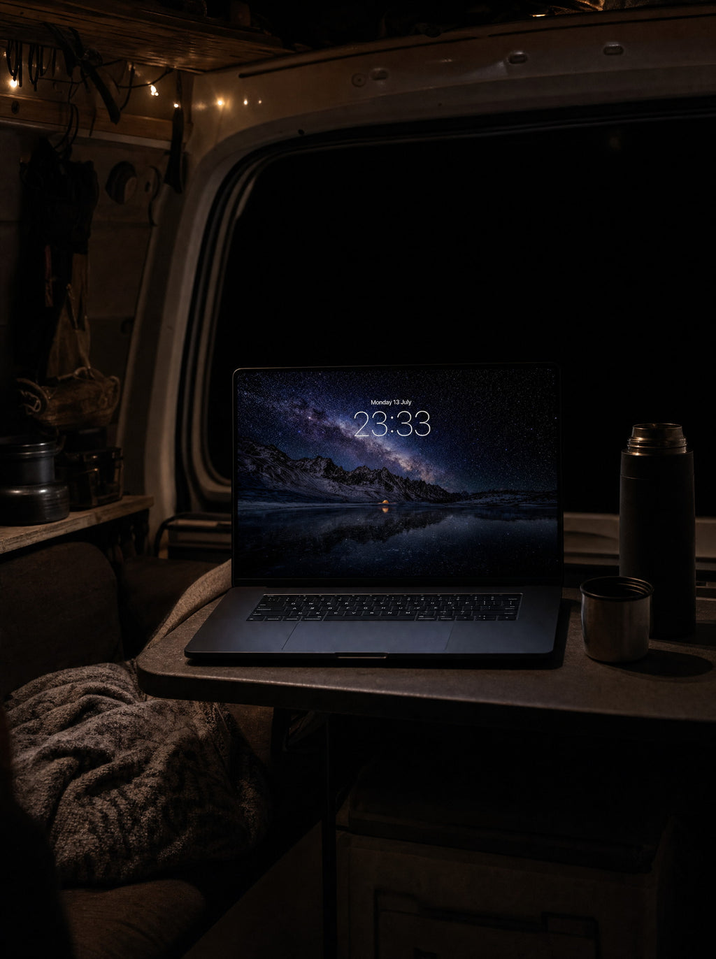 Starfall wallpaper on a MacBook Pro in a camper van parked in darkness