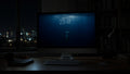 The Long Dive wallpaper on a large display in a dark studio office at night